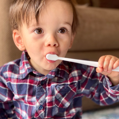 a toddler brushing his teeth